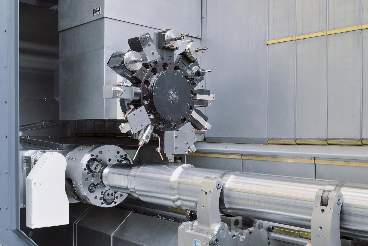 Close-up of a long shaft being machined on a CNC lathe.